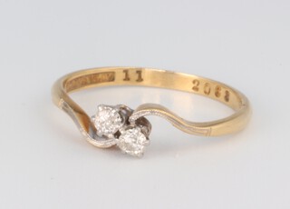 A yellow metal 18ct 2 stone diamond crossover ring, approx. 0.20ct, size O 1/2, 2 grams