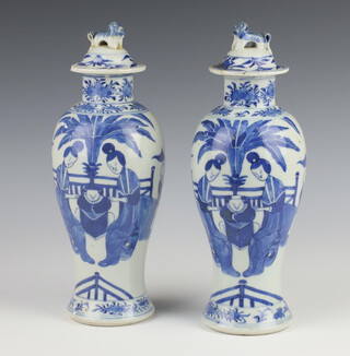 A pair of early 20th Century Chinese blue and white oviform vases and covers decorated with figures on pavilion terraces 27cm 