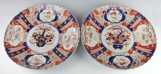 An impressive pair of 19th Century Imari scallop edge chargers decorated with panels of flowers 47cm 