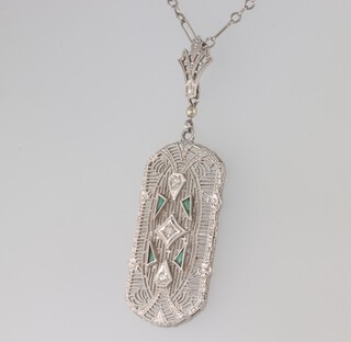 An Art Deco white metal 14k pendant set with diamonds and emeralds on a 14k white metal 40cm chain, chain 1.8 grams, pendant 2.6 grams 