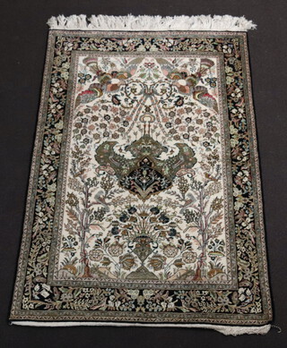 A Persian white and black ground floral patterned silk rug decorated a mosque lamp to the centre 163cm x 107cm 