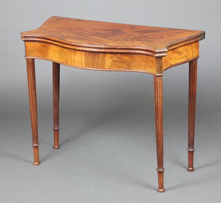 A Georgian mahogany tea table of serpentine outline raised on turned and fluted supports, 73cm h x 83cm w x 45cm d 