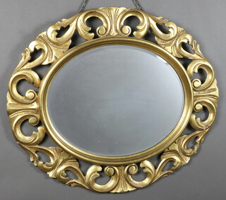 An oval bevelled plate wall mirror contained in a gilt carved wooden frame 66cm  x 75cm 