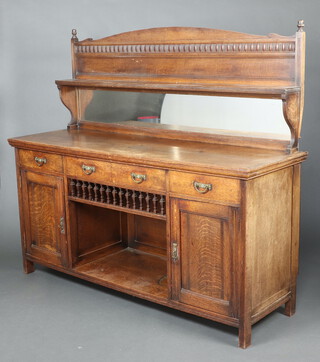 A Victorian oak chiffonier sideboard, the arched mirrored back fitted a shelf, the base a drawer above a recess flanked by 2 short drawers above cupboard enclosed by a panelled door 163cm h x 183cm w x 61cm d 