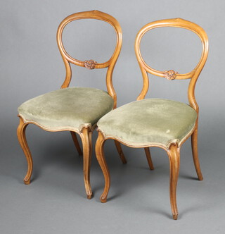 A pair of Victorian bleached walnut balloon back dining chairs with carved mid rails, over stuffed seats of serpentine outline, raised on cabriole supports 86cm h x 44cm w x 43cm d (seats 25cm x 27cm) 