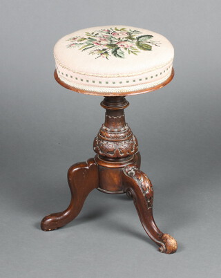 A Victorian carved walnut adjustable revolving piano stool, raised on a turned and carved column and tripod base 53cm h x 34cm diam. 