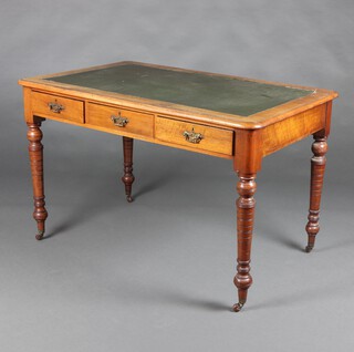 A Victorian bleached mahogany writing table with green inset writing surface, fitted 3 drawers, raised on  turned supports ending in ceramic casters 77cm h x 119cm w x 74cm d  