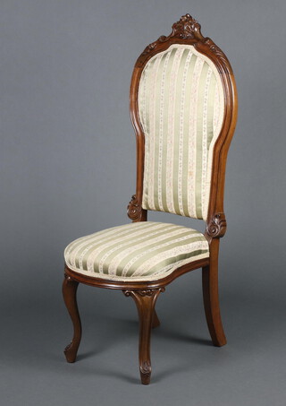 A Victorian carved walnut show frame nursing chair upholstered in Regency stripe, raised on cabriole supports 105cm h x 38cm w x 45cm d (seat 20cm x 30cm) 