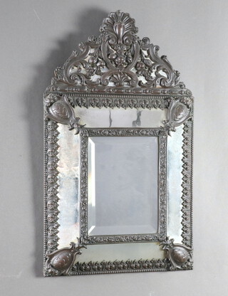 An 18th Century style Dutch cushion shaped mirror contained in an embossed gilt metal frame 64cm x 37cm 