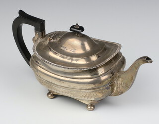 A silver teapot on ball feet with ebony mounts Sheffield 1924, gross weight 802 grams 