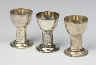 Three Danish silver egg cups decorated with a figure holder an umbrella, (dated 1947) 7cm, 154 grams 