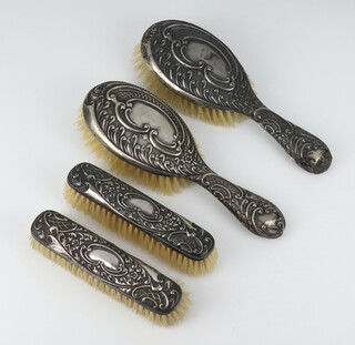 A silver repousse dressing table set comprising 2 hair brushes and 2 clothes brushes Birmingham 1912/13 