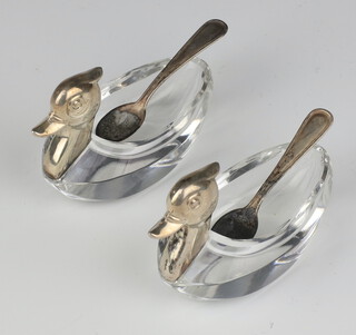 A pair of glass 935 standard mounted salts in the form of ducks together with 2 spoons