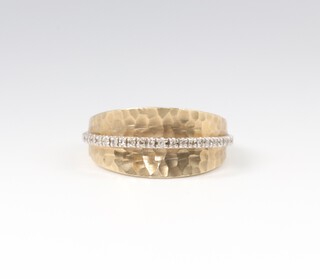 A 9ct two colour gold hammered pattern and diamond set ring, size O, 4.9 grams