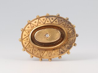 An Edwardian 15ct yellow metal oval etruscan brooch with a brilliant cut diamond 7.6 grams 35mm 