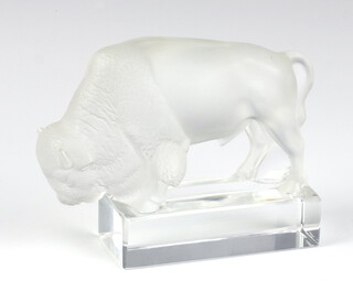 A modern Lalique opalescent figure of a bison standing on a rectangular base, etched lowercase marks 9cm 