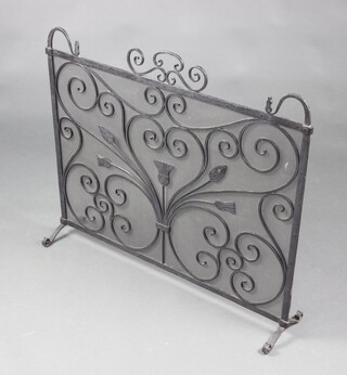 A wrought iron and mesh blacksmith made spark guard with thistle decoration 74cm h x 87cm w x 20cm d 