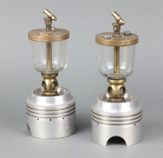 Two aluminium pistons with glass and brass oil reservoirs marked Pat 503444,  the base of the pistons marked 575801 B  21cm h x 10cm diam. 