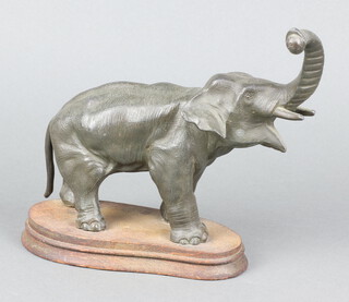A spelter figure in the form of a standing elephant, possibly the base of a mystery clock, raised on a shaped wooden base 15cm h x 27cm w x 8cm d 
