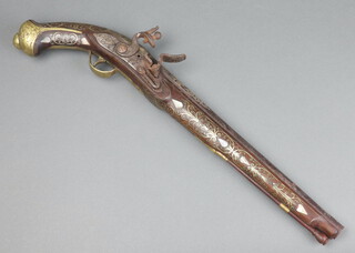 An 18th/19th Century Eastern flint lock pistol with 33cm barrel inlaid "silver", having walnut mounts inlaid "silver" and mother of pearl, complete with replacement ram rod  