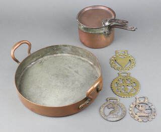 Temple and Cook ironmongers, a 19th Century copper saucepan with iron handle 9cm x 13cm, a copper twin handled pan 5cm x 29cm, the base marked B and 4 19th Century horse brasses 