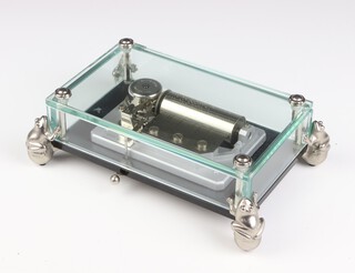 A Reuge Music musical box, the glass case raised on four metal frogs, playing 18th variation on a theme of Paganini No 7704, 1/50 21cm