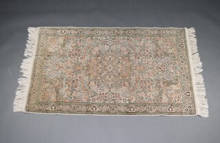 A pink and green ground  Persian rug with rectangular floral patterned medallion to the centre 155cm x 92cm  
