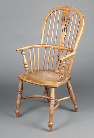 A 19th Century elm Windsor comb back carver chair with solid seat and crinoline stretcher, raised on turned supports 102cm h x 56cm w x 36cm d (seat 28cm x 26cm) 