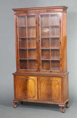 A Queen Anne style walnut display cabinet with moulded and dentil cornice, fitted adjustable shelves enclosed by astragal glazed panelled doors, the base enclosed by glazed panelled doors 195cm h x 105cm w x 39cm d 