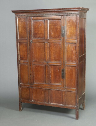An oak cabinet constructed of 18th Century panelled timber with moulded and dentil cornice enclosed by a panelled door with H framed hinges 172cm h x 115cm w x 53cm d 