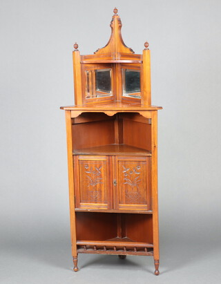 An Edwardian carved walnut corner cabinet, the raised back fitted 2 bevelled plate mirrors above recess with cupboard enclosed by panelled doors above recess, raised on turned and block supports 158cm h x 60cm w x 42cm d 