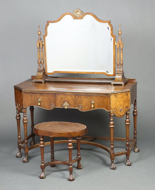 A 1930's Italian style walnut dressing table fitted a drawer, raised on cup and cover supports with U shaped stretcher and scrolled feet 80cm h x 121cm w x 60cm d, together with a separate arched bevelled plate dressing table mirror with carved shell to the crest 76cm h x 99cm w x 23cm d and an oval dressing table stool with woven cane seat, raised on cup and cover supports with X framed stretcher 
