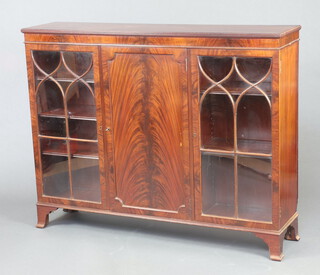 An Edwardian mahogany display cabinet, the centre section fitted shelves enclosed by panelled doors flanked by cupboards fitted shelves enclosed by astragal glazed panelled doors, raised on bracket feet 107cm h x 137cm w x 33cm d 