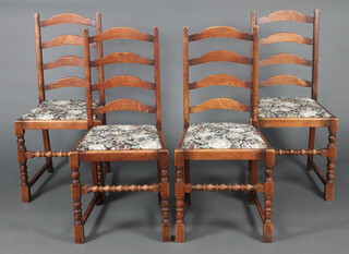 A set of 4 oak framed ladder back dining chairs with upholstered drop in seats, raised on turned and block supports 
