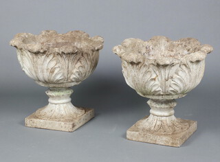 A pair of well weathered concrete garden urns of circular form on square bases, in 2 sections, 46cm h x 51cm diam. 