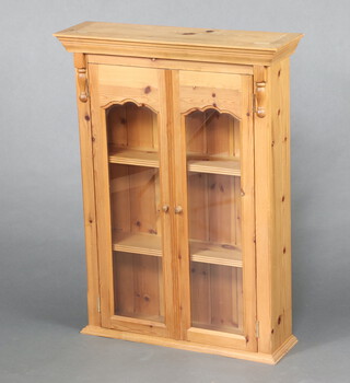 A Victorian style pine hanging display cabinet with moulded cornice, fitted shelves enclosed by glazed panelled doors 94cm h x 70cm w x 21cm d 