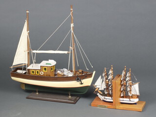 A wooden model of a fishing boat 51cm h x 44cm w x 13cm d together with a pair of book ends in the form of the 4 masted sailing ship "Constitution" 15cm h x 26cm w x 10cm d 