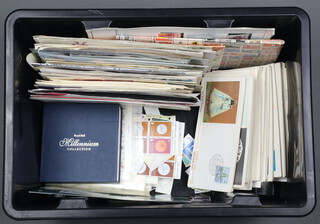 A small collection of Continental first day covers and loose stamps in a black plastic box 