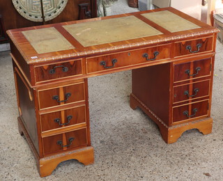 A yew pedestal desk with green inset writing surface above 1 long and 8 short drawers raised on bracket feet 76cm h x 122cm w x 60cm d (contact marks in places)