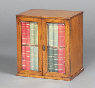 An Edwardian oak and cedar smoker's cabinet, interior fitted 2 drawers in the form of faux leather books enclosed by a pair of bevelled plate panelled doors 30cm h x 27cm w x 20cm 