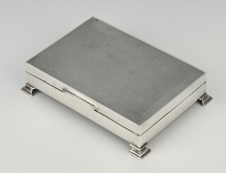 A rectangular silver engine turned cigarette box on bracket feet Birmingham 1964, 13cm 