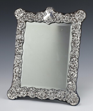 A Victorian style repousse silver rectangular photograph frame with vacant cartouche and bevelled plate, Sheffield 1991, 29cm 