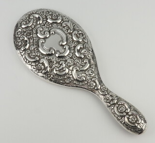 A Victorian repousse silver hand mirror decorated with scrolls and flowers and vacant cartouche London 1895 
