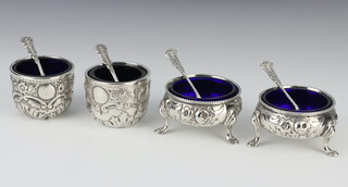 A pair of Victorian silver table salts raised on hoof feet London 1864, a pair of Edwardian ditto decorated with leaves London 1898, together with 4 spoons, all with liners, 172 grams 