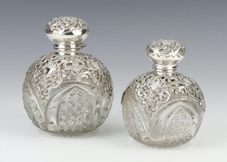 An Edwardian silver mounted globular scent bottle with cut glass body, decorated with scrolls Birmingham 1902, 11cm, a ditto Birmingham 1903, 9.5cm 