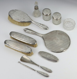 An engine turned silver dressing table set Birmingham 1925 comprising hand mirror, hair brush, 2 clothes brushes, a jar lid, 2 mounted bottles together with 4 other items 