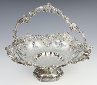 A Victorian pierced repousse silver swing handled basket decorated with scrolls and flowers with engraved monogram, London 1857, 702 grams, 28 cm