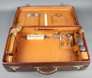 Three silver mounted toilet jars London 1920 and 1923, contained in a leather suitcase with some accessories 