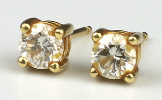 A pair of yellow metal 18k diamond studs 0.4ct