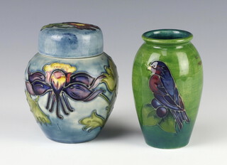 A modern Moorcroft squat shaped pale blue jar and cover decorated with clematis 10cm, a ditto green ground vase decorated with a bird 10cm 